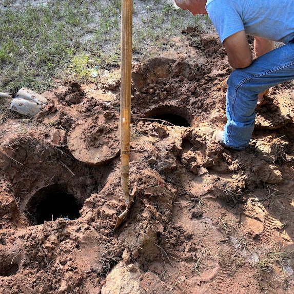 Boyce Septic technician excavating a septic system access point