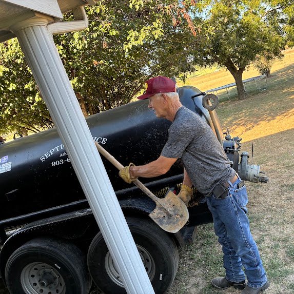 Boyce Septic technician working beside the company pumping truck